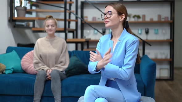 Satisfied Therapist Looking Back at Teenage Patient Crossing Hands Looking at Camera Smiling