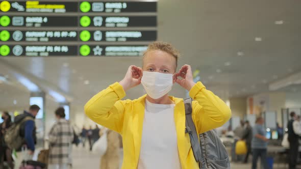 Stylish woman wearing on protective mask on her face against background of crowd of people