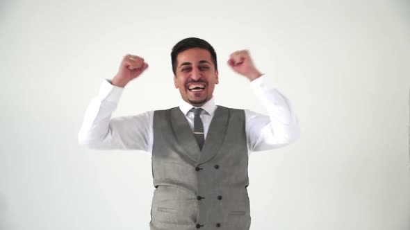 An American Businessman in a Vest Is Jubilant and Waving His Arms Happily. Back White Background