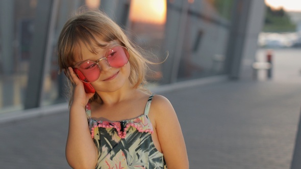 Tourist Kid Girl Wearing Stylish Sunglasses Use Phone. Child Using Smartphone for Call Talk. Tourism