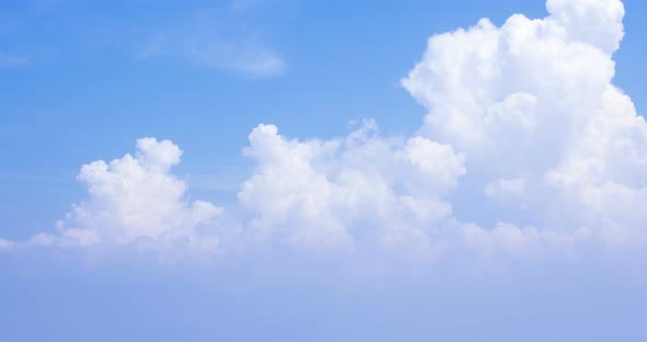 The motion of clouds on the background of the azure sky.