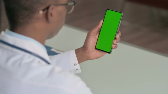 Young African Doctor Using Smartphone with Chroma Screen