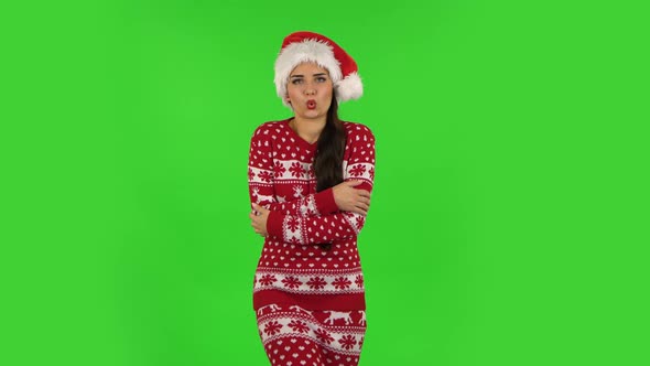 Sweety Girl in Santa Claus Hat Froze and Trying To Keep Warm. Green Screen