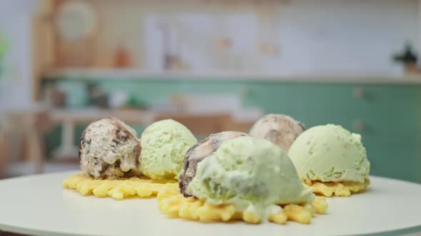 Waffles with Pistachio and Chocolate Ice Ream Topping Rotating in the Kitchen in Slow Motion