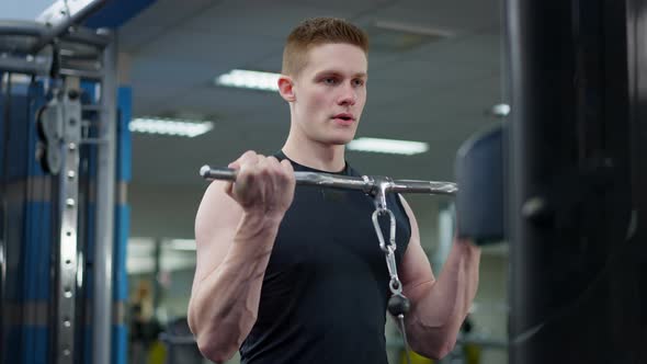 Confident Handsome Young Caucasian Man Training in Gym Lifting Resistance Weights