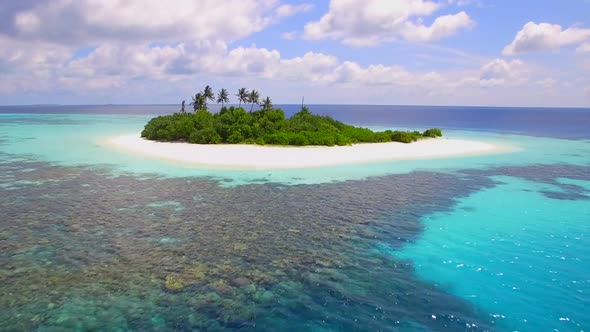 Aerial drone view of a coral reef and scenic tropical island in the Maldives.