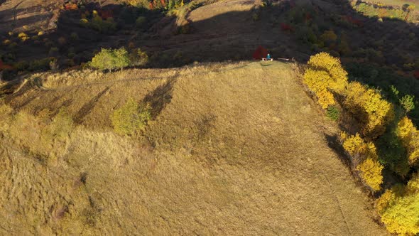 Flying Over a Hiking Woman Relaxing on a Mountain Peak. Aerial View by Drone