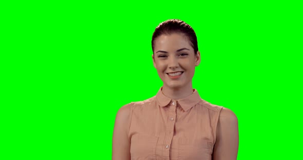 Smiling beautiful woman standing against green screen