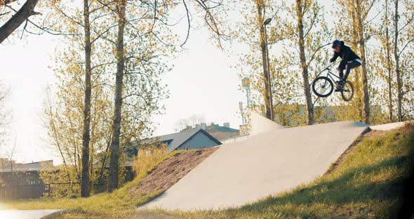 Crazy Teenager with Stunt Riding Skills on Low Bike Rides Around Skatepark Jumps Off Sloping