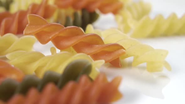 Colored uncooked Italian fusilli pasta. Close-up falling