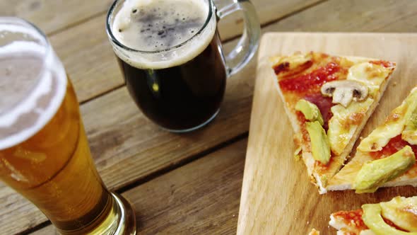 Slices of pizza with glasses of beer and soft drink