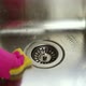 Female hand wearing pink rubber glove cleaning metallic sink - VideoHive Item for Sale