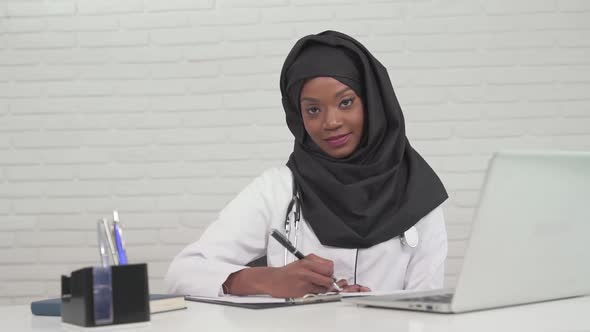 Female Doctor Writing Notes in Office
