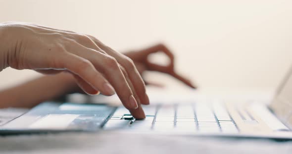 Female Hands Typing on Laptop Keyboard on Bed at Bedroom Close Up View