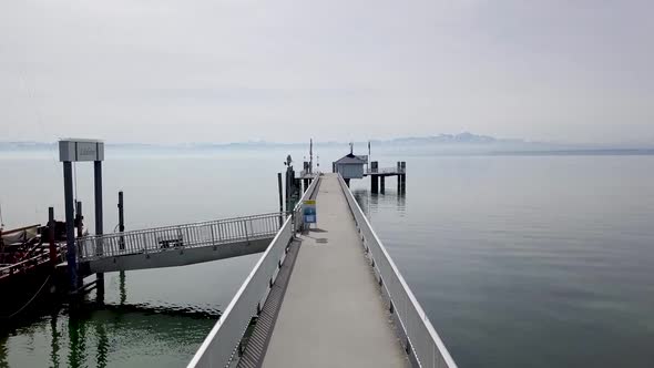 Drone footage of pier with alps in background. Lake of Constance, Immenstaad.