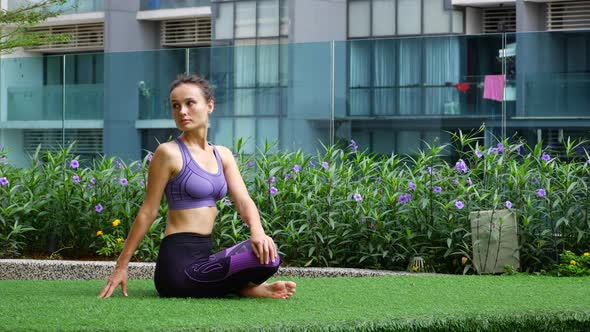 Young Woman Doing Stretching on the Grass