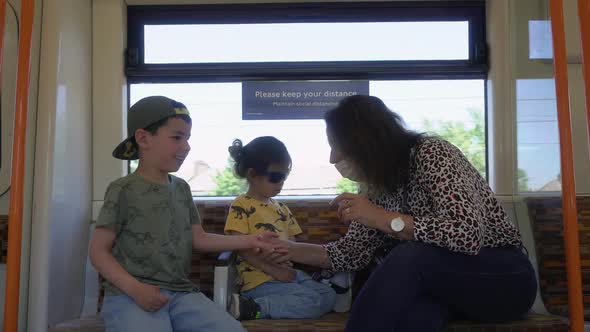 mature woman playing with kids on a train grandma with child social distancing