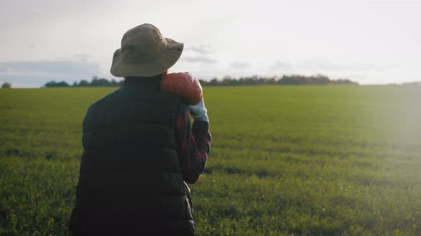 Young Woman Farmer in Hat Holding Orange Pumpkin in Her Hands the at Field at Sunset Time . Pumpkin