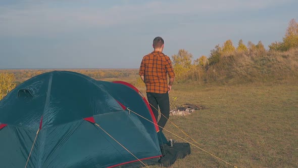 Man in Checkered Shirt Goes Out of Tent on Field Slow Motion