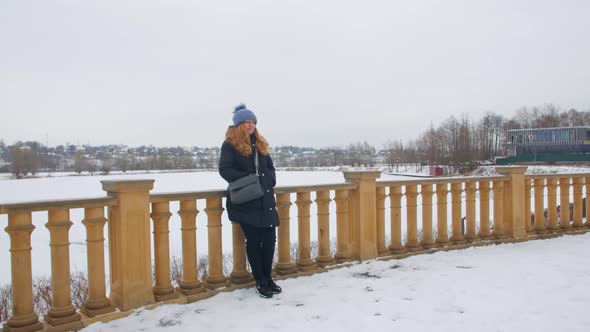 A Woman Standing On A Winter Street