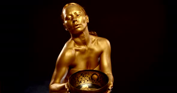 Female Dancer Is Covered Shiny Golden Dye Dancing with Tibetan Bronze Bowl