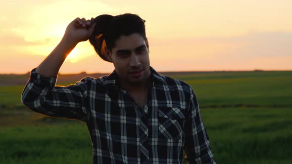 Portrait of a Young Farmer in a Field Looking at the Camera and Smiling at Sunset