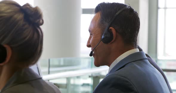 Business people wearing headsets in a modern office