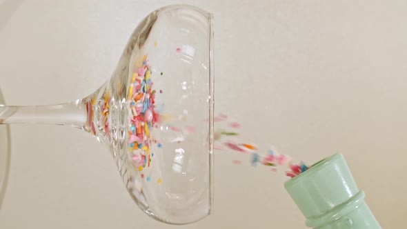 Colorful Candy Confectionery Run Poured Into a Wineglass Glass on Green Background