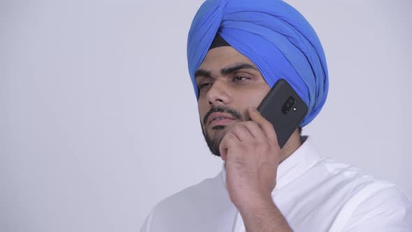 Face of Happy Young Bearded Indian Sikh Man Talking on the Phone