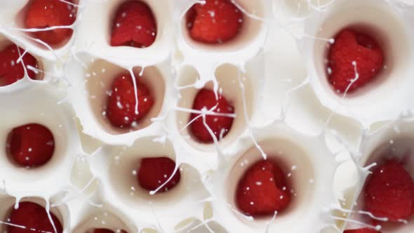 Camera follows tossing raspberries in yoghurt. Overhead shot. Slow Motion.