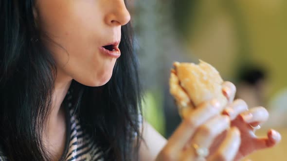 Young Women Eating Hamburger in Restaurant