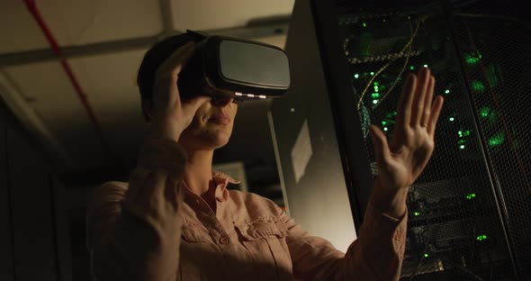 Smiling caucasian woman wearing vr headset by computer server