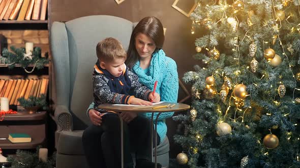 Mother and Little Son Writing Letter to Santa Claus