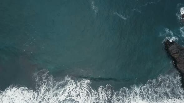 Aerial Top View of Ocean Waves Breaking on Dark Rocks on Black Sand Beach, Canary Islands, Tenerife