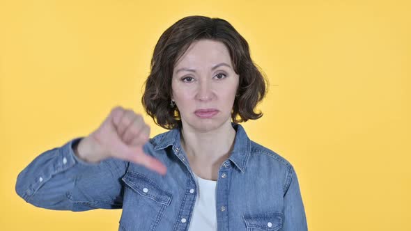 Thumbs Down By Old Woman Yellow Background