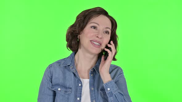 Old Woman Talking on Smartphone on Green Chroma Key Background 