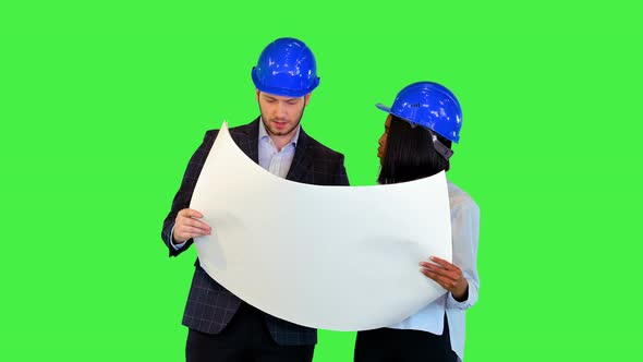 Young Female Architect and Expert Engineer Analyzing Blueprint Together Work Team Wearing Hardhats