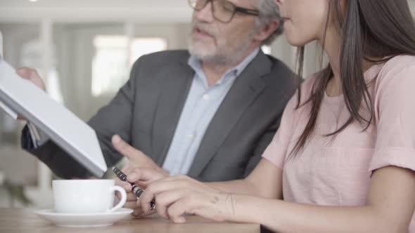 Cropped View of Bearded Businessman Showing Contract To Partner