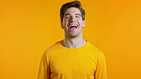 Amazed European Man Shocked, Saying YEAH. Handsome Guy Surprised To Camera Over Yellow Background.