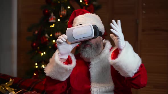 Portrait of Santa Claus Wearing Virtual Reality Goggles with Wow Surprised Expression on His Face