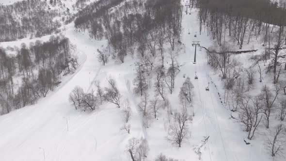 Flying over rope-way with gondolas at mountain resort Crystal Park in Bakuriani. Snowy winter day.