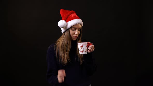 A girl drinking from a Christmas mug