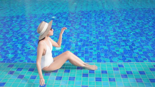 Young asian woman enjoy around outdoor swimming pool for leisure