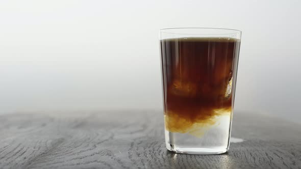 Slow Motion Making Espresso Tonic in Tumbler Glass Pour Espresso in Tonic with Ice Cube