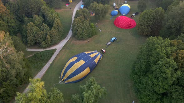 Aerial View of Hot Air Balloons Prepare for an Summer Early Morning Flying in Park in Small European