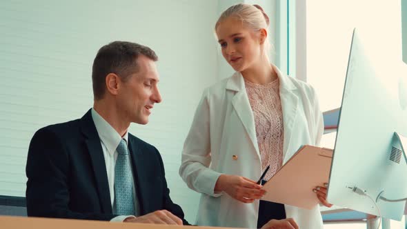 Two Business People Talk Project Strategy at Office