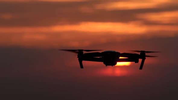 Copter Revolves Around Its Axis Against the Background of a Fiery Orange Sunset