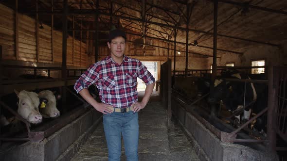 Young Smiling Farmer in Checkered Shirt Takes Care of His Farm