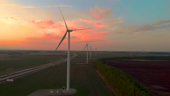 Drone flying towards windmills with sky in background