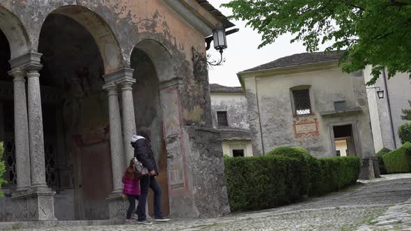 A mother and her little daughter carrying a teddy bear visiting the sacred mountain of Varallo chris